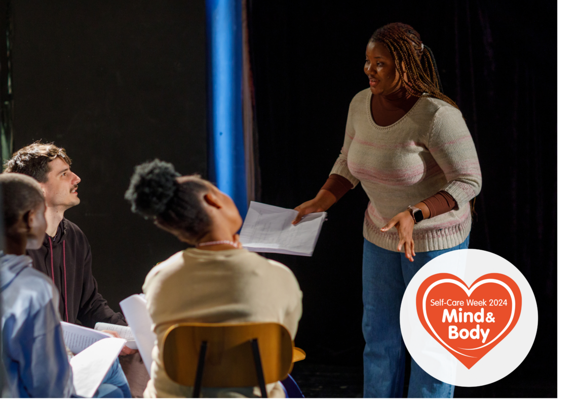 4 adults doing a drama exercise in a theatre