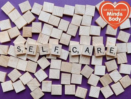 The word 'self care' spelt out in wooden scrabble letters on a background of purple with blank scrabble blocks surrounding them and a red heart that says 'Self-Care Week 2004 Mind & Body'