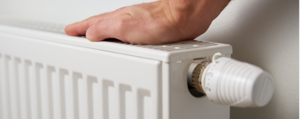 hand on top of a radiator testing temperature