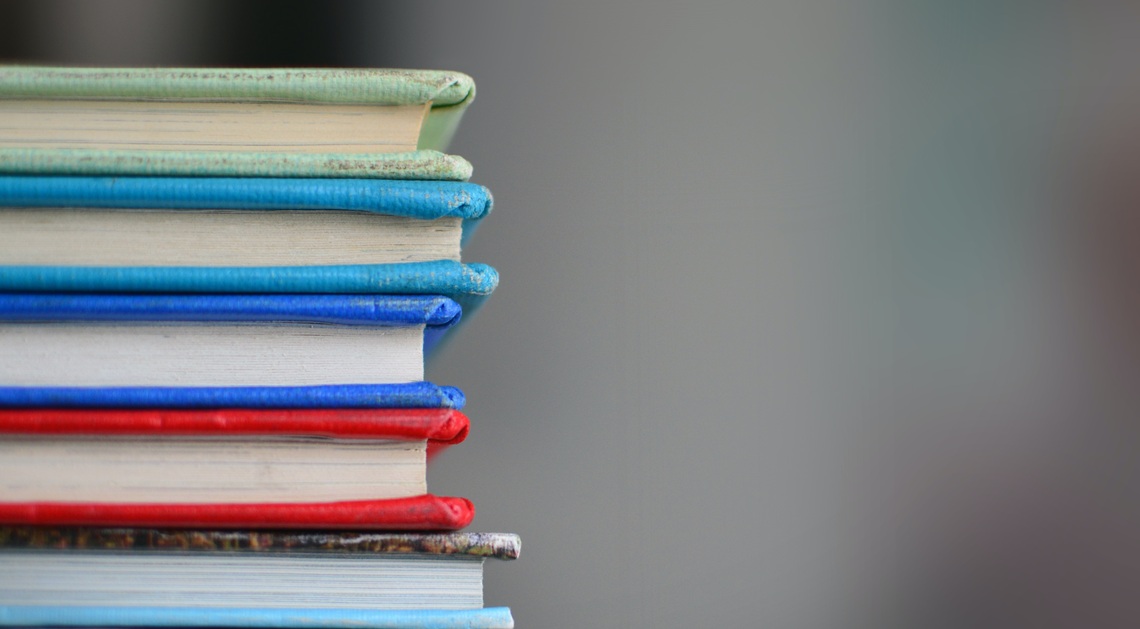 A stack of coloured books against a blurred background